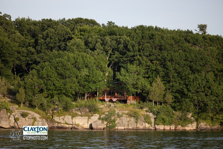 a train traveling down tracks next to a body of water surrounded by trees