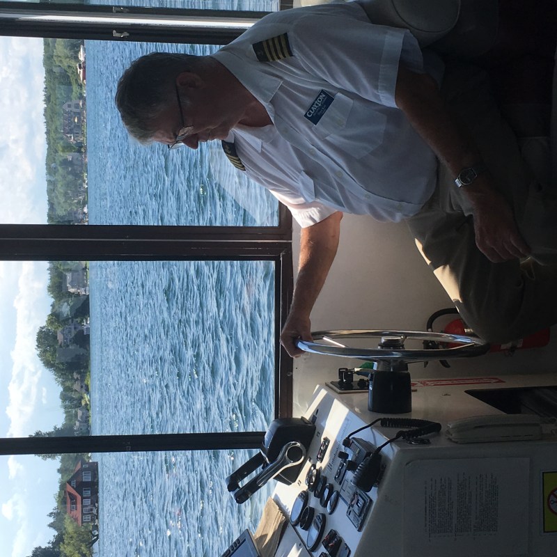 a man standing in front of a window with water in the background