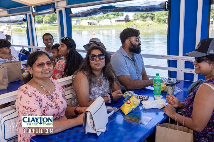 a group of people sitting at a table with a cake