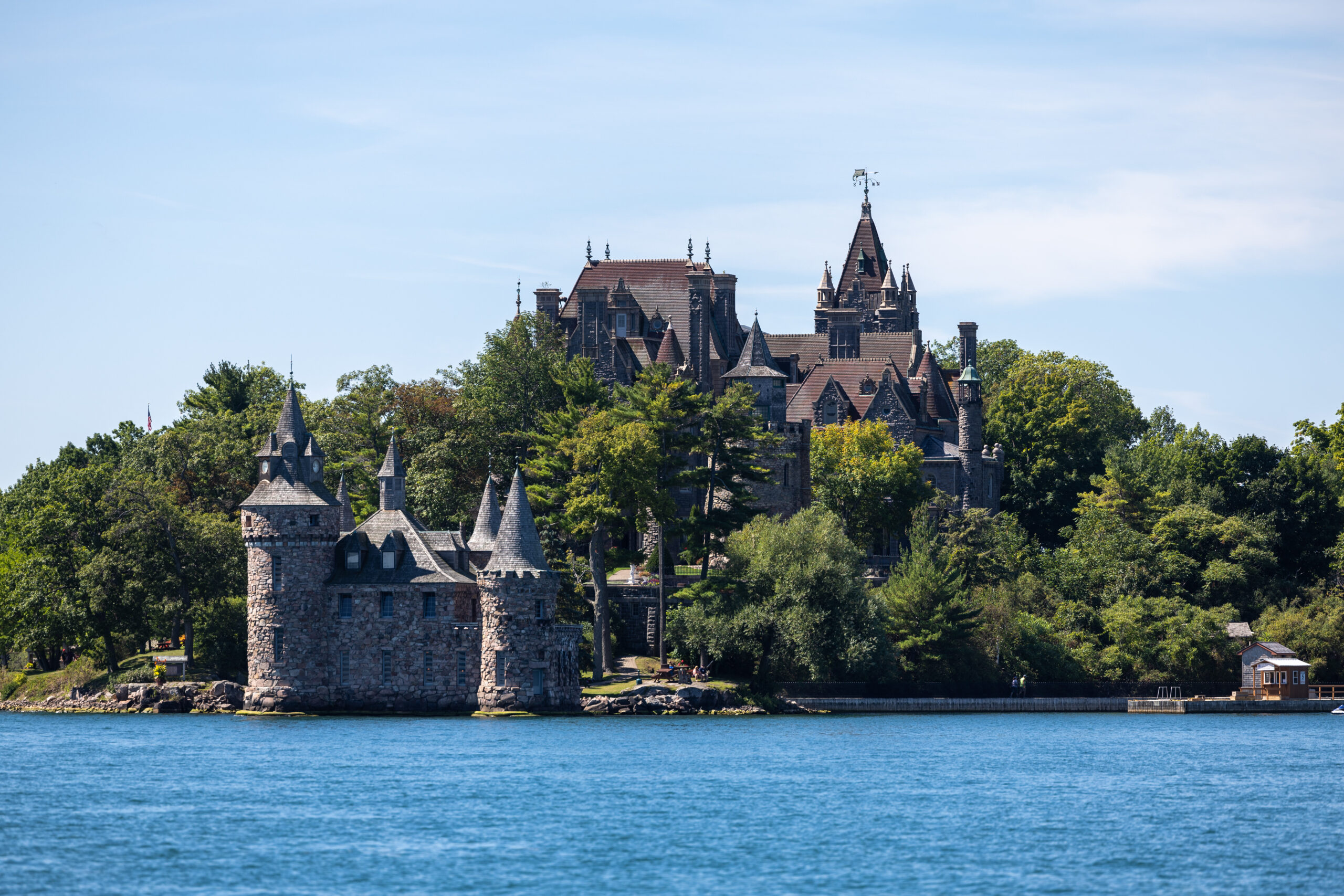 a large ship in a body of water with Boldt Castle in the background