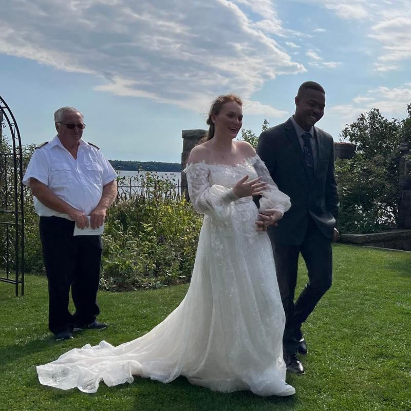 a group of people standing on top of a grass covered field